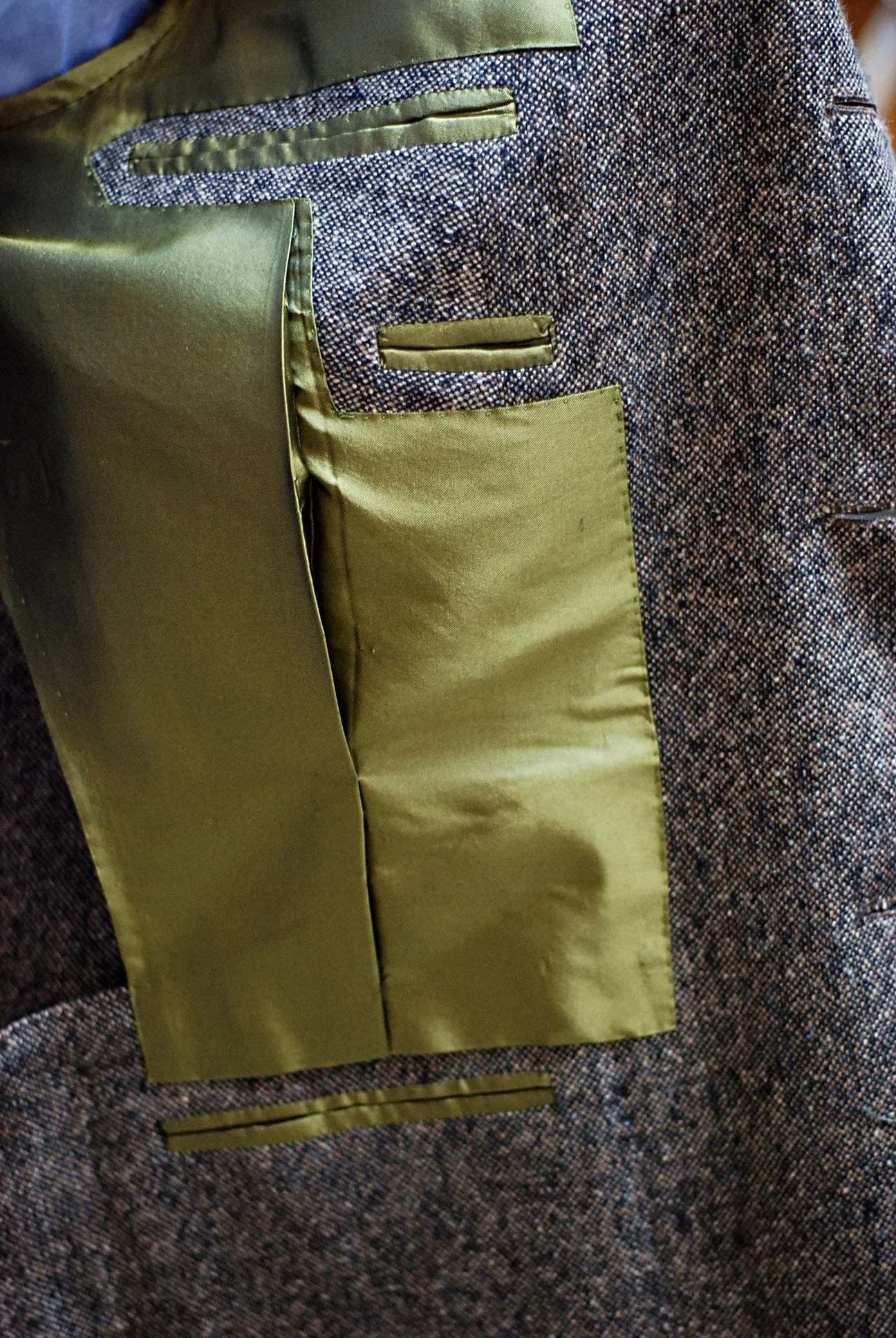 Glossy olive-gold Bemberg lining inside a tweed jacket with interior pocket