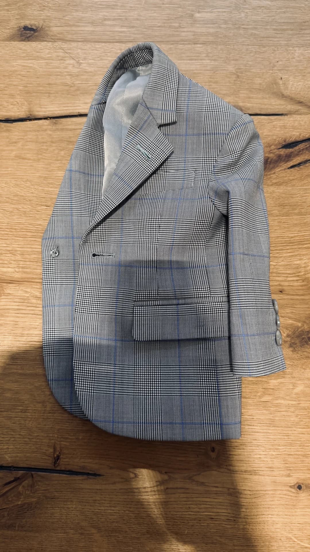 Glen check bespoke jacket with blue overcheck laid on oak floor at Endel Tailor Bangkok