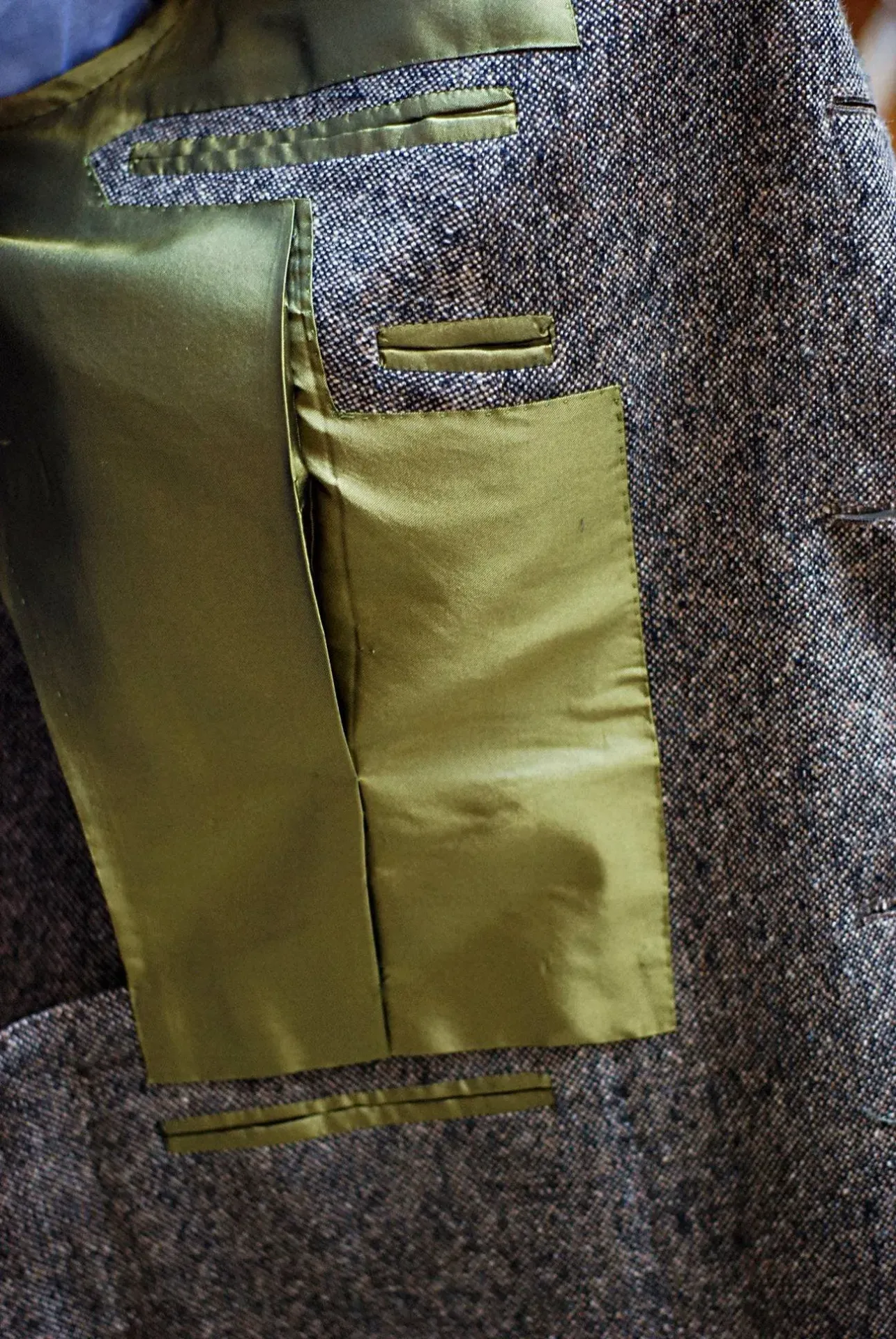 Glossy olive-gold Bemberg lining inside a tweed jacket with interior pocket
