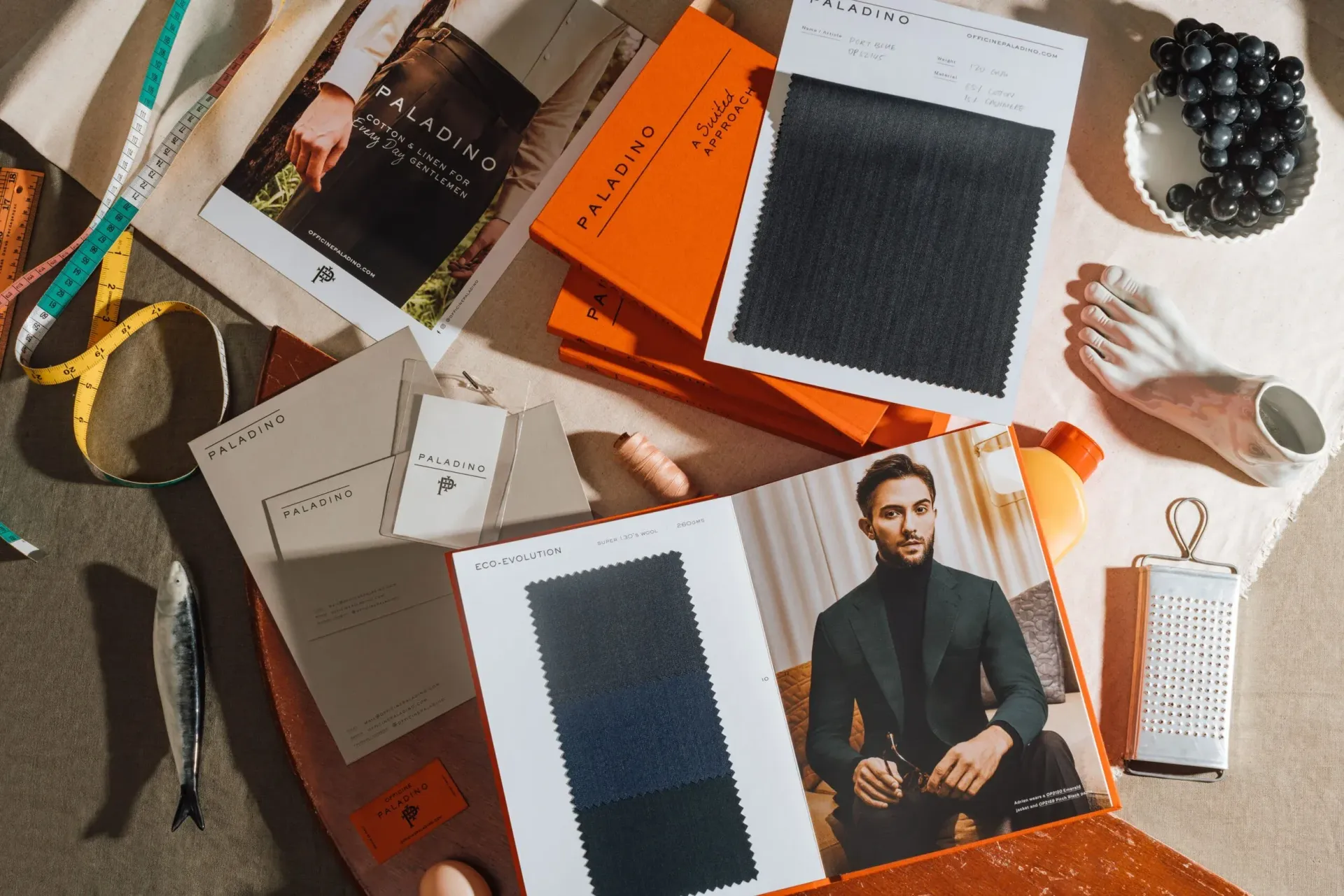 Paladino fabric books and swatches with tape measure and a tailored suit photo