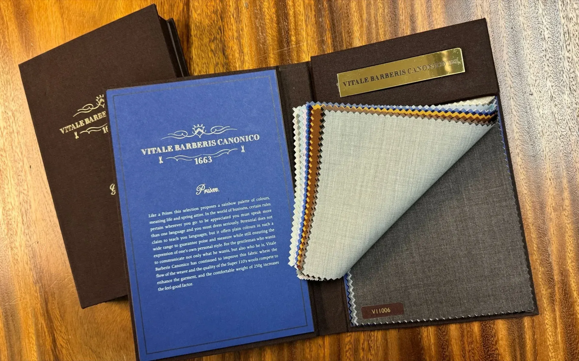 Open Vitale Barberis Canonico swatch book showing light blue and grey suiting cloth