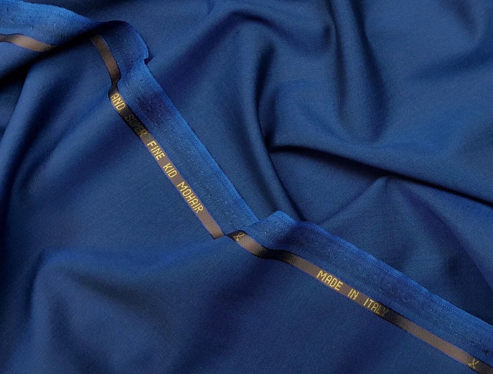 Royal blue fine kid mohair cloth with a crisp sheen and gold selvedge text