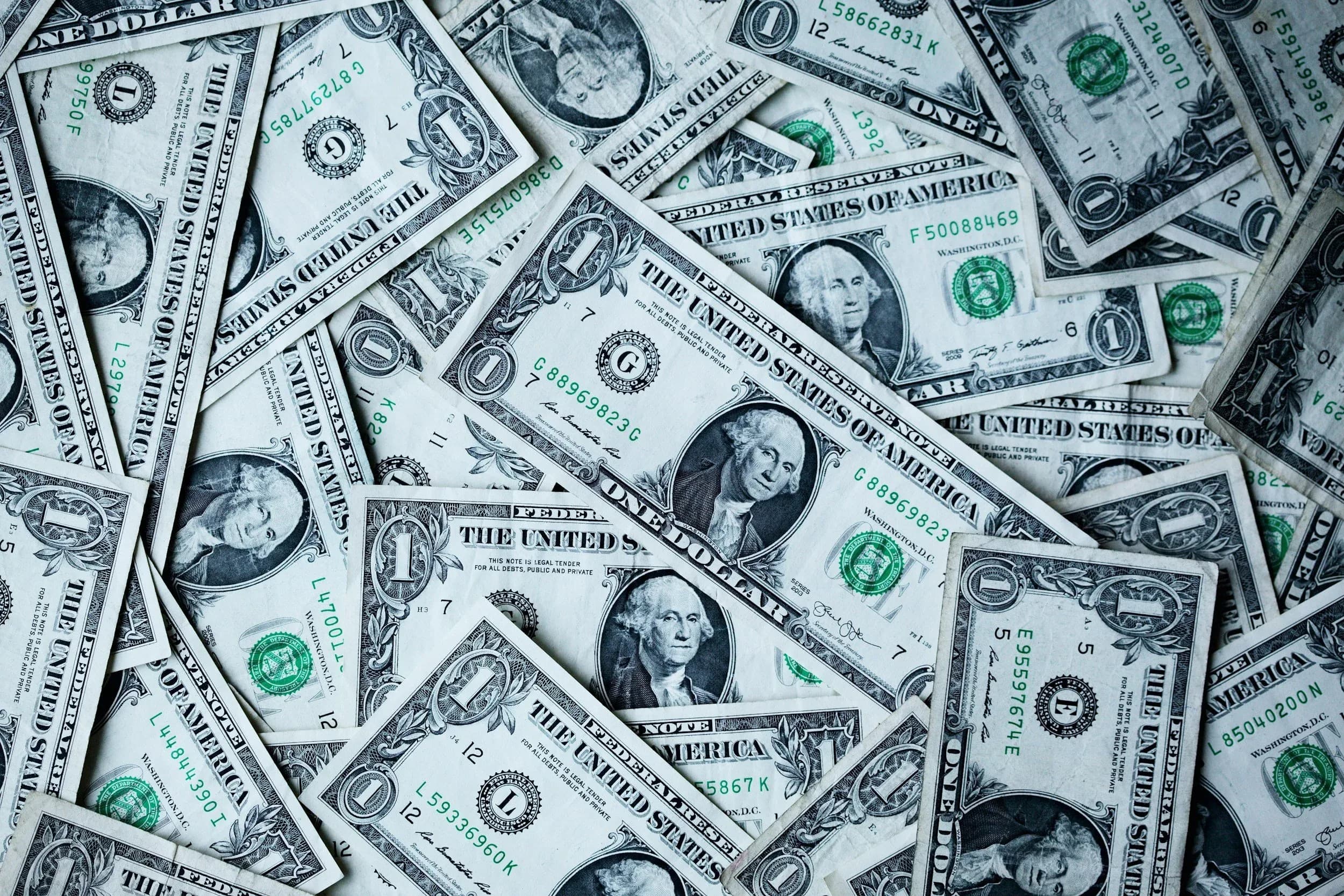 Scattered United States one-dollar bills covering a surface